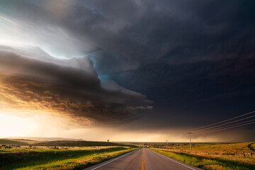 Supercell storm with dramatic clouds over a road at sunset