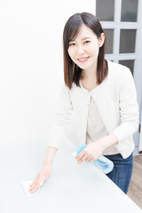 Woman disinfecting desk with alcohol