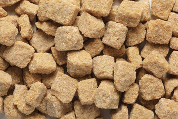 Brown rough cut sugar cubes texture background.