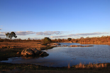 Lit by the sun's last rays, a South African river flows peacefully on a July evening.