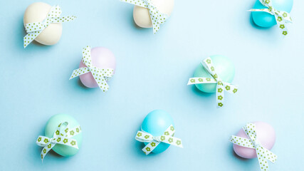 Easter message. Colourful egg with tape ribbon on pastel blue background in Happy Easter decoration. Foil minimalist egg design, modern top view template.