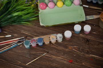 Table with paint and brush for painting easter eggs
