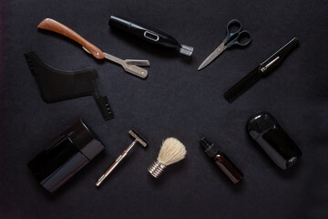 Top view of various men shaving accessories and body care on black background
