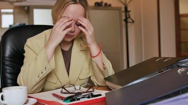 A lot of Paperwork and sad woman. Bored sad worker tired unmotivated and disinterested in dull work with laptop paperwork. Office clerk working, adding folders more work.