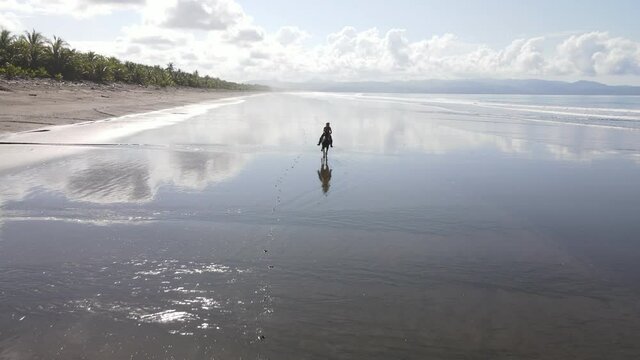 Epic woman on a galloping horse unreal mirror beach water reflection Costa Rica zancudo
