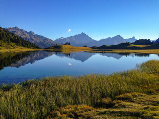 Beautiful blue lake in the mountains and the peaks mirroring in the still water. 