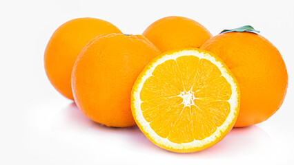 Cut in half and slice a ripe orange with golden yellow peel. Lots on white background with shadows and reflections