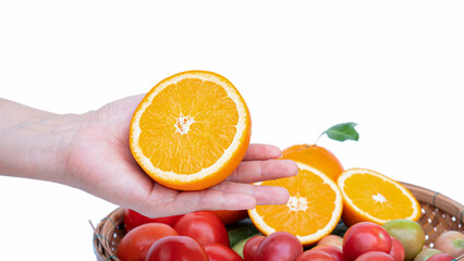 Female left hand Hold a half ripe orange in your hand. Bamboo basket put vegetables and fruits high in vitamin C like oranges, tomatoes on white background.