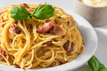 Classic homemade carbonara pasta with pancetta, egg, parmesan cheese, basil and cream sauce. Italian food