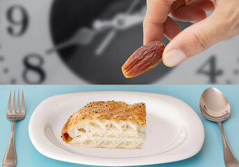White plate standing on wooden background. Hand holding  pitted dates. close up