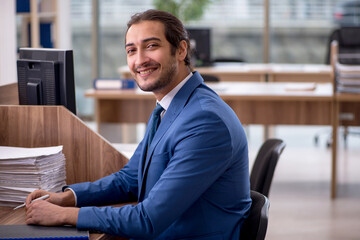 Young male employee unhappy with excessive work in the office