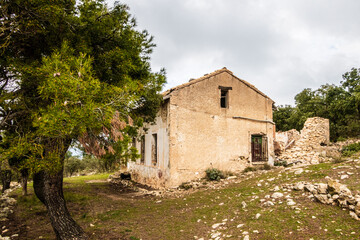 abandoned country house in a Mediterranean forest, on a cloudy day.