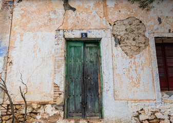 Fototapeta na wymiar Old faded and damaged wooden door, in an old and abandoned country house. 