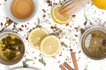 Herbal tea, top view. Dry herbs, lemon slices and tea cups on white. Herbs in bulk, zero waste and eco-friendly lifestyle, herbal medicine concept.	