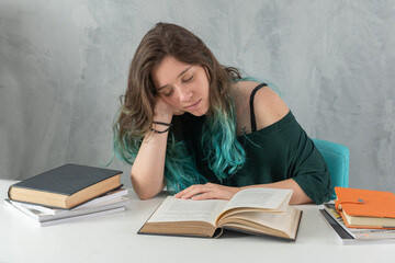 tired and sleep woman with books on the table