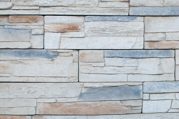 stone tiles of sand, gray and light colors are laid on the wall in the form of a beautiful decor