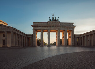 Brandenburg Gate in Berlin, Germany with sunlight shining through during Sunset.