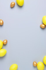 Easter yellow and golden eggs on grey background. Flat lay, copy space.