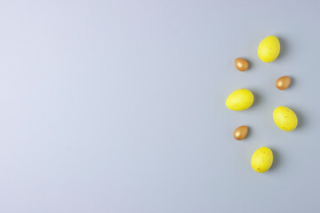 Easter yellow and golden eggs on grey background. Flat lay, copy space.
