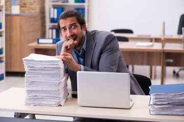 Young male employee unhappy with excessive work in the office