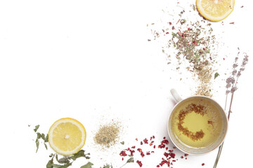 Herbal tea, top view with copy spce. Dry herbs, lemon slices and tea cups on white. Herbs in bulk,...