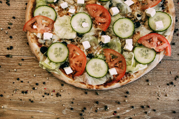 Vegetable pizza with mozzarella, fresh tomatoes and cucumber