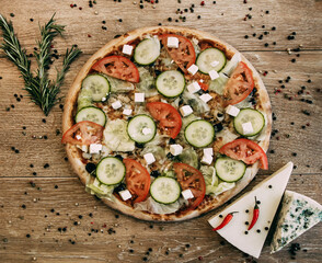 Vegetable pizza with mozzarella, fresh tomatoes and cucumber. Two types of blue cheese