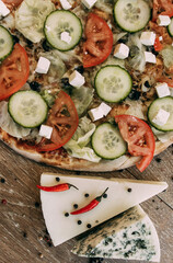 Vegetable pizza with mozzarella, fresh tomatoes and cucumber. Two types of blue cheese