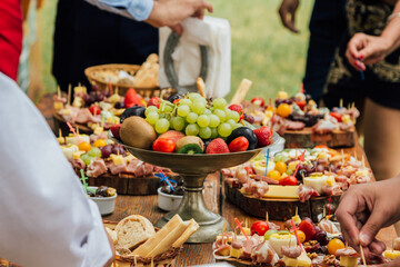 Bandeja con frutas en una mesa de banquete con otros alimentos alrededor