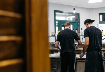 Two chefs in the process of working in a pizzeria restaurant