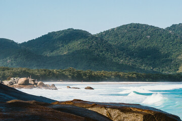 Vista panorámica de una playa con selva y montañas con cielo de fondo