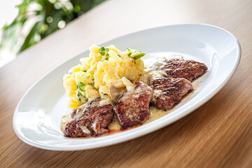 Cooked food - pork tenderloin with bra, pine nuts and spring onions.