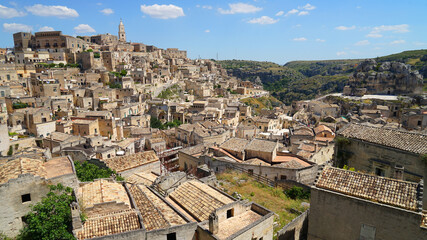 Obraz premium Sassi di Matera aerial panoramic cityscape with warm sunset colour ,popular tourist travel place, guided tour concept, Basilicata, Italy