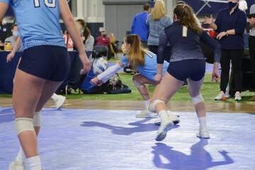 Young female volleyball player passing the ball while wearing a mask