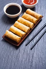 Fried spring rolls with vegetables on rustic background