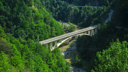 A concrete arched bridge in a mountainous area. The construction is a part of the famous Transfagarasan Road, the road that pierces the Fagaras Mountains. Carpathia, Romania.