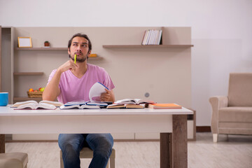 Young male student preparing for exams at home