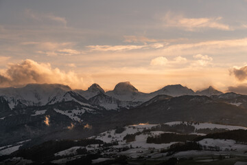Fototapeta na wymiar swiss mountains during sunset with fog and clouds and snowy mountains in the alps