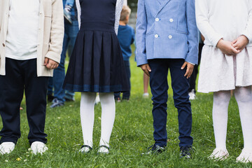 Russia Moscow 30.08.20. Back to primary school concept.Children hold hands,go to first grade.Graduating ceremony.Shirt,skirt,dress,uniform.Party for parents,teachers in park,yard.Last day,end of year
