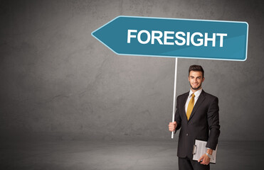 Young business person in casual holding road sign with FORESIGHT inscription, new business direction concept