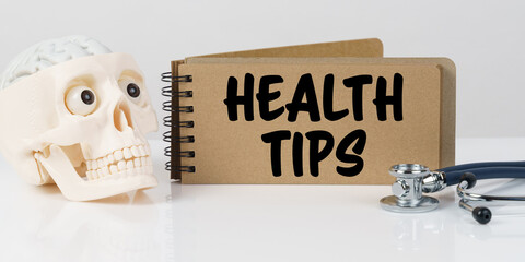 On the table lies a skull, a stethoscope and a notebook with the inscription - HEALTH TIPS