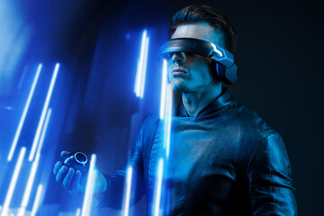 Man on dark virtual reality background. Guy using VR helmet. Augmented reality, future technology, game concept. Blue neon light. Futuristic holographic interface to display data.