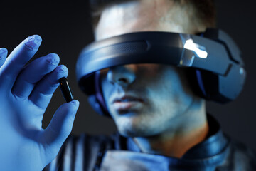 Guy using VR helmet. Augmented reality, future technology, game concept. Blue neon light. Man...