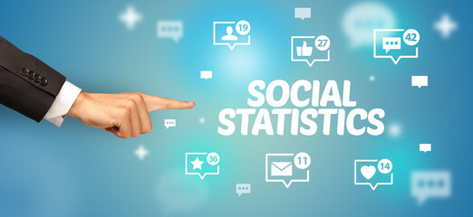 Close-Up of cropped hand pointing at SOCIAL STATISTICS inscription, social networking concept