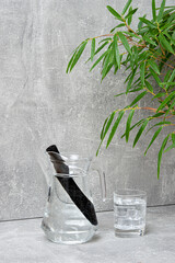 Bamboo charcoal water filter stick, green leaf and glass of water. Natural bamboo charcoal is a...