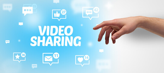 Close-Up of cropped hand pointing at VIDEO SHARING inscription, social networking concept