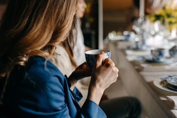 Closeup of a woman with a cup of coffee at breakfast.