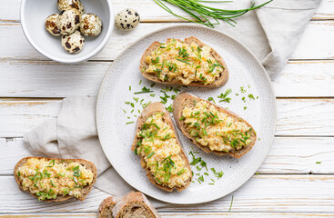 Healthy breakfast, scrambled quail eggs topped with chopped chives