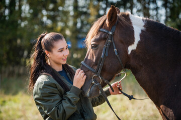 Obraz premium A beautiful girl is happy with her horse and shows her love and tenderness.