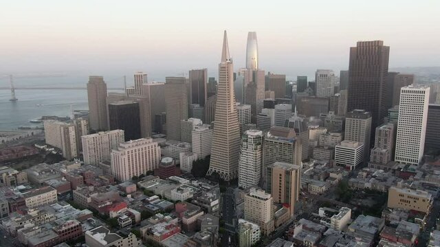 Aerial panning and reversing shot of downtown buildings surrounded by urban neighborhoods - San Francisco, California